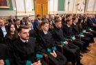 Studenci siedzą w rzędach podczas uroczystości