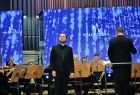 Koncert - mężczyzna stojący przed orkiestrą śpiewa