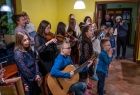 Dzieci występują przed Mikołajem i Marszalkiem Witoldem Kozłowskim. Dzieci śpiewają i grają na instrumentach. 