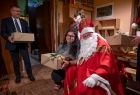 Dziewczyna stoi obok Świętego Mikołaja w ręku trzyma prezent. Obok nich również ze świątecznym prezenterem stoi Marszałek Witold Kozłowski. 
