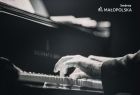 Czarno - białe zdjęcie rąk pianisty na klawiaturze fortepianu