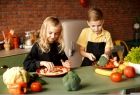 Dzieci przygotowują w kuchni posiłek z owoców i warzyw