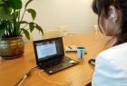 Telekonferencja, kobieta siedzi przed ekranem laptopa