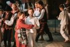 Dzieci tańczą na scenie w strojach regionalnych