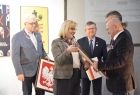 Na pierwszym planie widać radną województwa MArte Mordarską, radnego Stanisława Pasonia i Marszałka małopolski Witolda Kozłowskiego, przekazują oni godła Małopolski i Polski. 