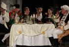 Grupa osób w strojach turystów na scenie