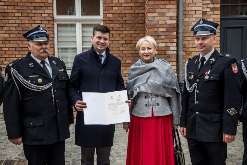 Wicemarszałek Łukasz Smółka i Iwona Gibas z zarządu województwa stoją ze strażakami OSP.