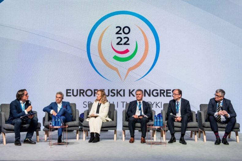 Uczestnicy debaty siedzą na fotelach ustawionych na scenie. Za nimi widoczny napis Europejski Kongres Sportu i Turystyki.