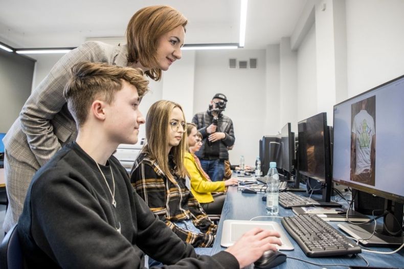 Marta Malec-Lech z zarządu województwa razem z uczniami patrzy w monitor.