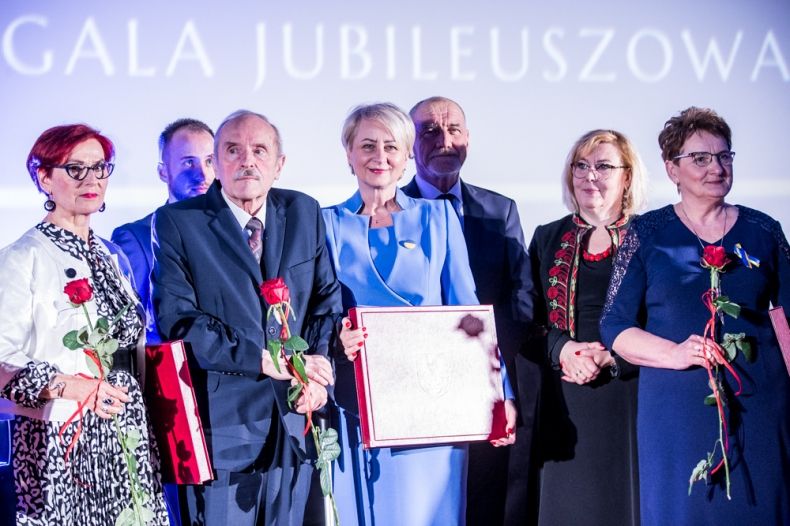 Uczestnicy gali na scenie. Z tyłu napis Gala Jubileuszowa.