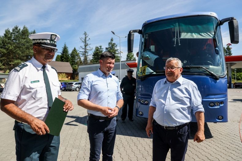 Minister Adamczyk i wicemarszałek Smółka stoją z generałem Inspekcji Transportu Drogowego. Za nimi widoczny autokar.