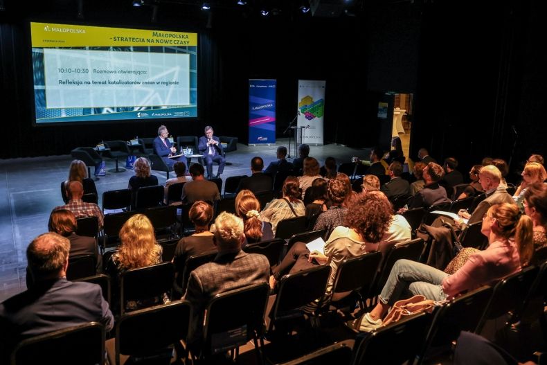 Widok na publiczność siedzącą podczas konferencji.