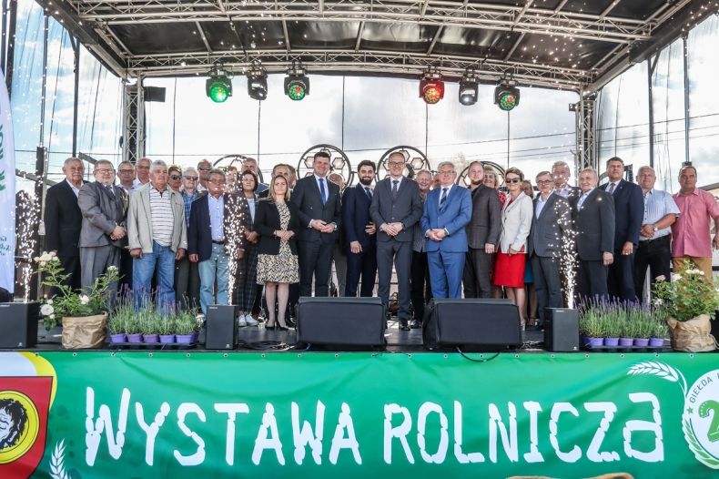 Wspólne pamiątkowe zdjęcie z bannerem z napisem "Wystawa Rolnicza"