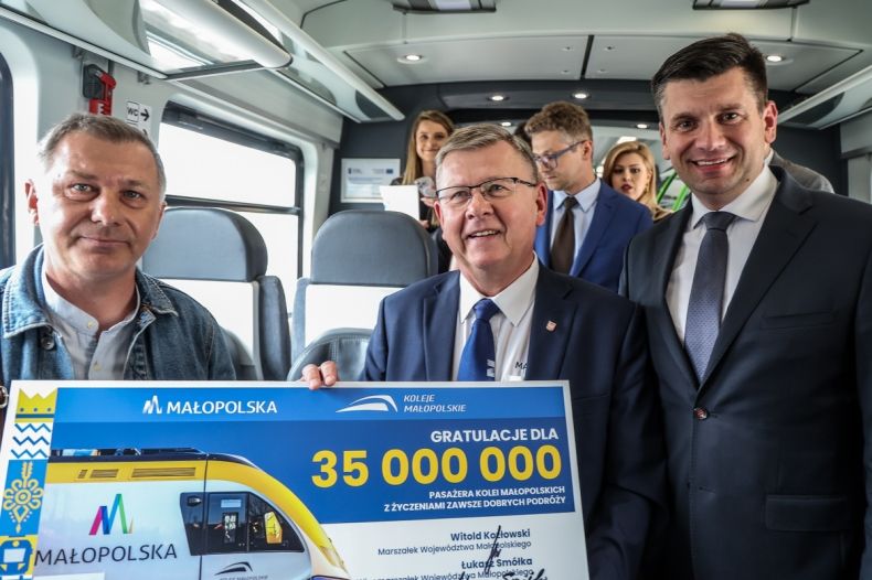 Marszałek Witold Kozłowski i wicemarszałek Łukasz Smółka stoją w pociągu z 35 milionowym pasażerem.