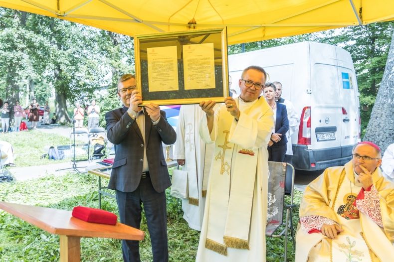 Marszałek Witold Kozłowski pokazujący z księdzem odznaczenie