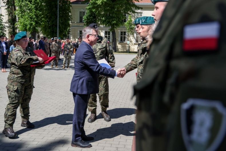 Marszałek Witold Kozłowski ściska dłoń żołnierzowi.