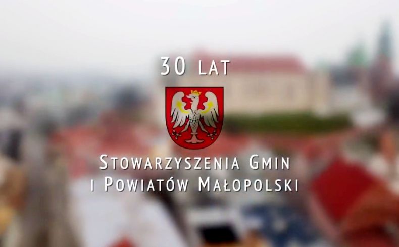 Napis "30 lat Stowarzyszenia Gmin i Powiatów Małopolski", w tle widok na Kraków