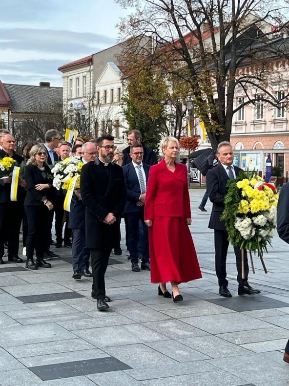 Iwona Gibas z zarządu województwa wraz z radnym województwa Rafałem Stuglikiem i Dyrektorem Muzeum Dom Rodzinny Ojca Świętego Jana Pawła II w Wadowicach ks. Łukaszem Piórkowskim składają kwiaty przy pomniku