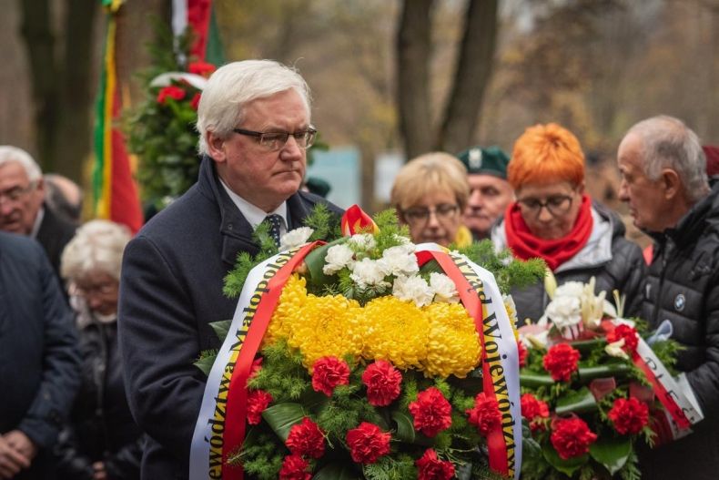 Józef Gawron składa wiązankę kwiatów przed kaplicą