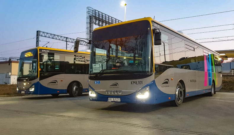 Nowoczesne autobusy Iveco w barwach Małopolski stoją na dworcu kolejowym.