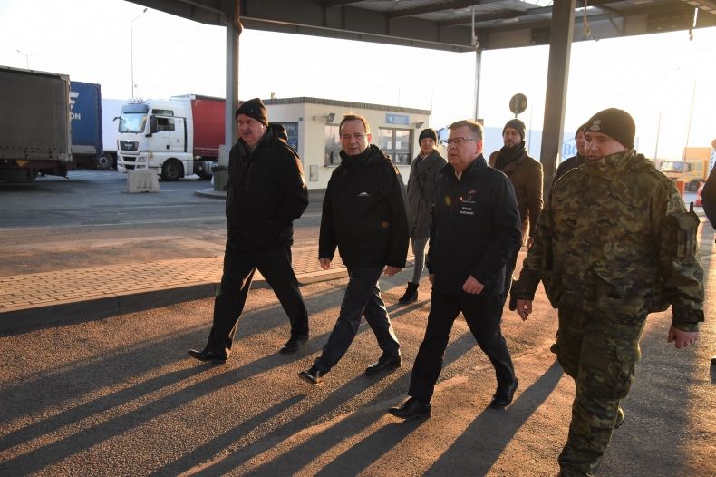 Cztery osoby, w tym marszałek Witold Kozłowski, idą w stronę namiotów, gdzie udzielana jest pomoc