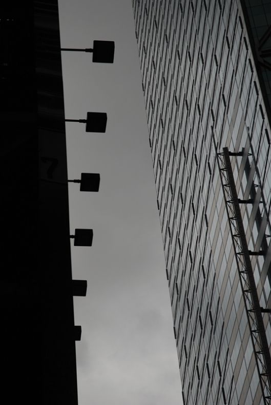 Fotografia czarno - biała autorstwa Eryka Tohla, przedstawiająca szklane wieżowce