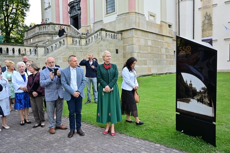 Grupa osób stoi obok baneru z napisem "550 lat obecności paulinów na Skałce"