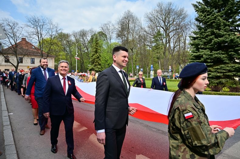 Wicemarszałek Łukasz Smółka trzyma flagę RP