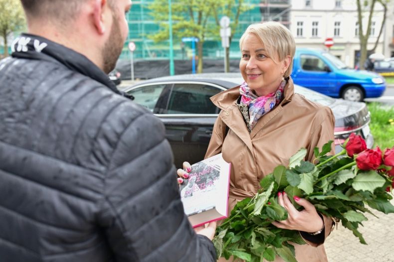 Iwona Gibas z Zarządu Województwa Małopolskiego wręcza książkę mieszkańcowi Oświęcimia