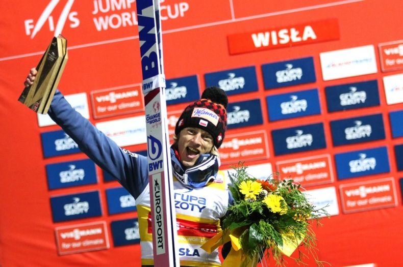 Dawid Kubacki na podium w geście zwycięstwa 