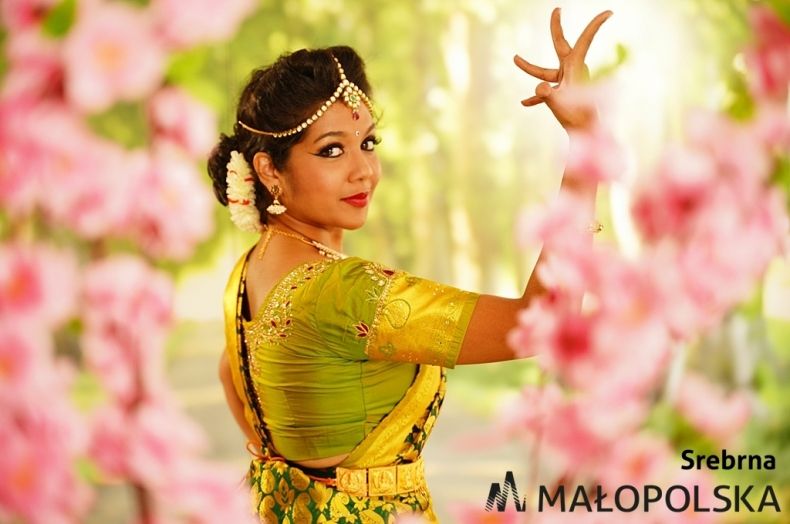 Na kolorowym zdjęciu hinduska w barwnym stroju w pozycji tanecznej