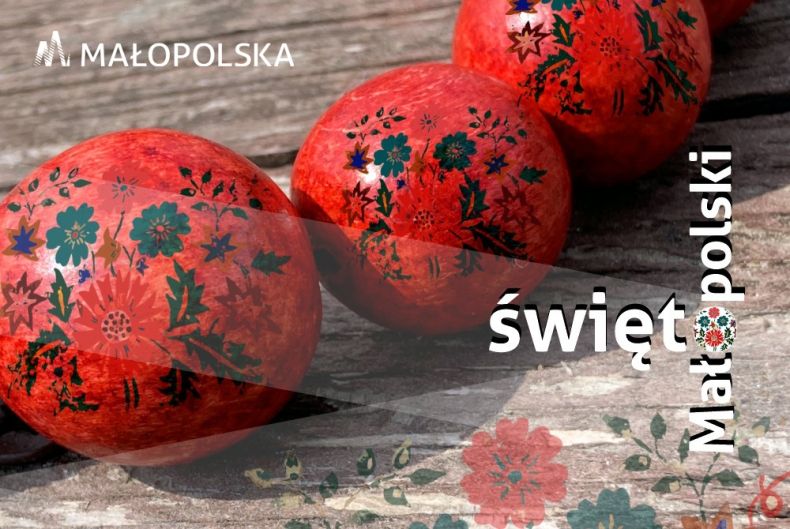 Czerwone kule z regionalnym motywem kwiatowym i napis "Święto Małopolski".