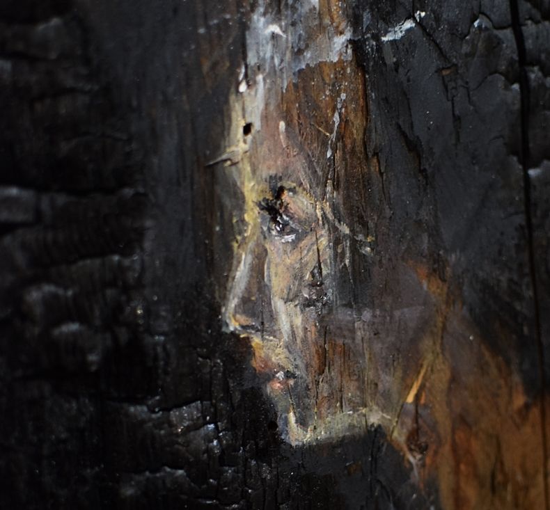 Portret kobiety autorstwa Barbary Rudzińskiej, kobieta namalowana z profilu na spalonej drewnianej desce
