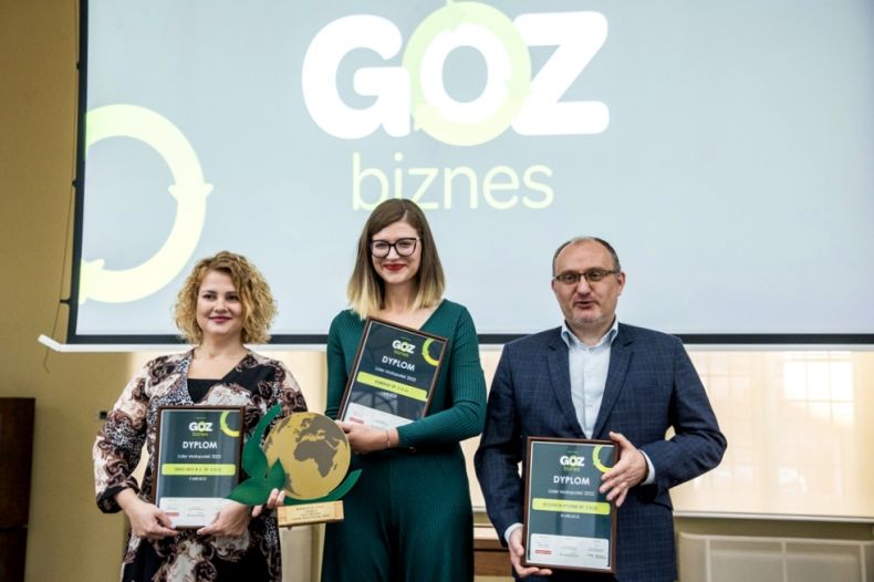 Laureaci z nagrodami na tle ekranu z napisem "GOZ Biznes"