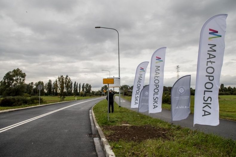 Nowa droga, obok stoją flagi z napisem Małopolska.