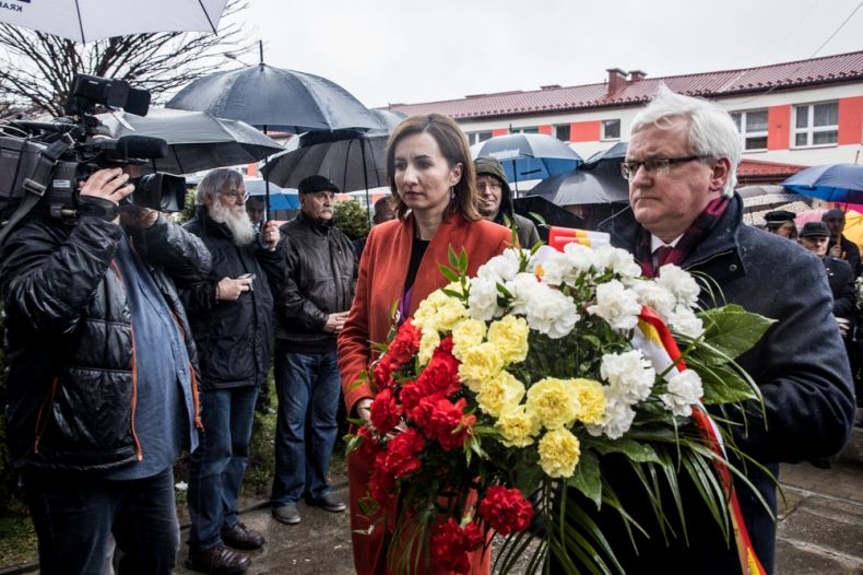 Wicemarszałek Józef Gawron i Marta Malec-Lech z zarządu województwa składają kwiaty przed tablicą.