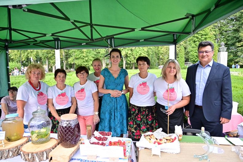 Marta Malec-Lech z zarządu województwa z uczestnikami jednego ze stoisk obecnych na wydarzeniu pozują do wspólnego zdjęcia