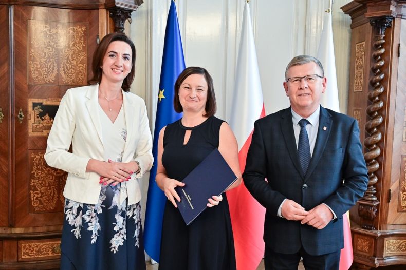 Marszałek Witold Kozłowski, Marta Malec-Lech z zarządu województwa i Agnieszka Rozkrut stoją w gabinecie Marszałka.