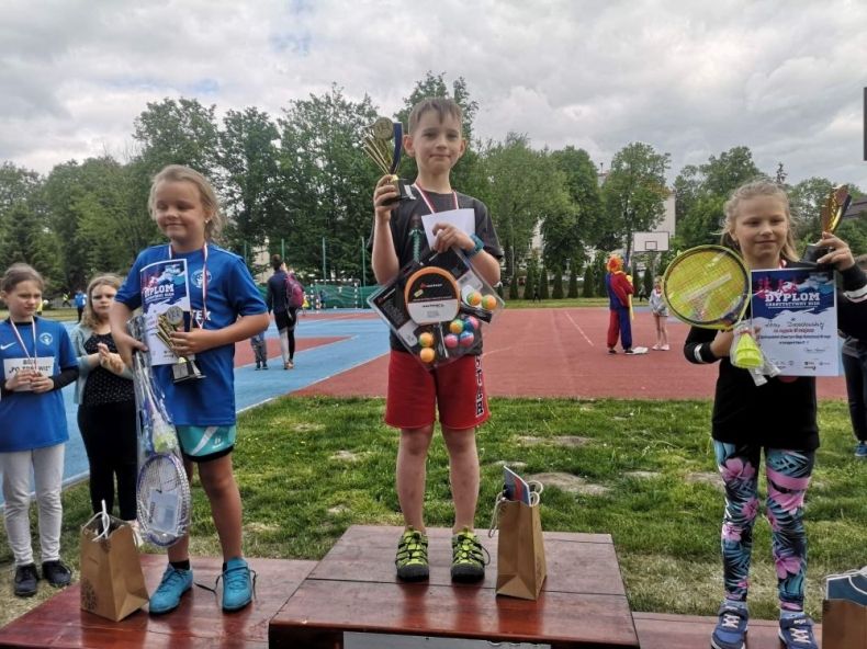 Dzieci stojące na podium z nagrodami.