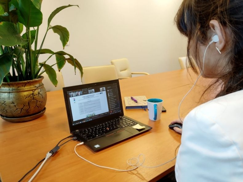 Telekonferencja, kobieta siedzi przed ekranem laptopa