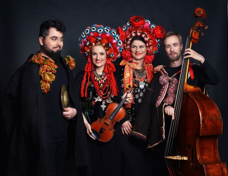 cztery osoby z instrumentami muzycznymi w strojach regionalnych