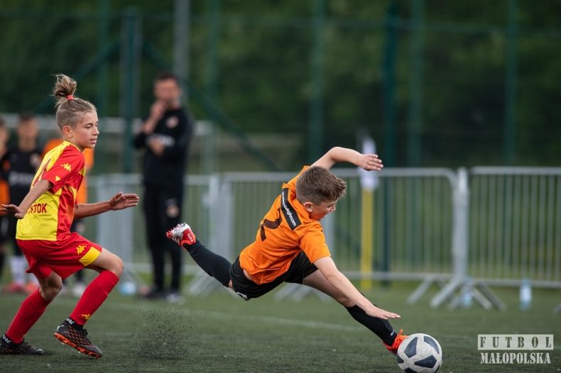 młody piłkarz upada na boisko, walcząc o piłkę
