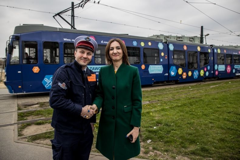 Marta Malec-Lech podaje rękę motorniczemu tramwaju w Krakowie, promującego Festiwal Zawodów 2022 