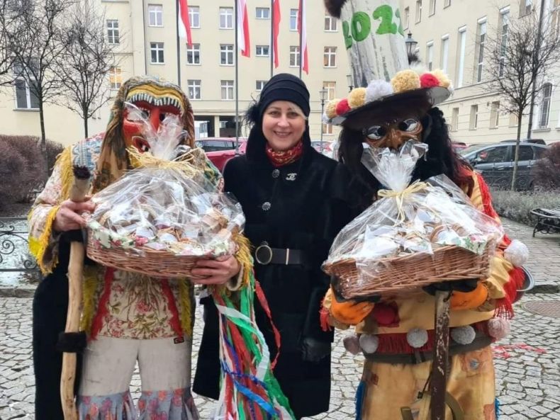Iwona Gibas z zarządu województwa stoi z przebranymi w stroje kolędnikami.