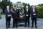 Uczestnicy wydarzenia stoją przed przekazanym strażakom quadem