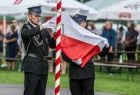 Strażacy z OSP wciągają na maszt flagę Polski.