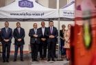 Wicemarszałek Łukasz Smółka stoi pod namiotem z napisem www.wielka-wies.pl obok ministra Andrzeja Adamcyzka i innych ludzi.