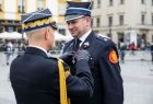 Generał straży pożarnej przypina medal do munduru wicemarszałkowi Łukaszowi Smółce.