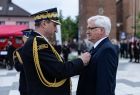 Generał straży pożarnej przypina medal wicemarszałkowi Józefowi Gawronowi.