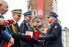 Wicemarszałek Łukasz Smółka odbiera pamiątkowy medal od komendanta.